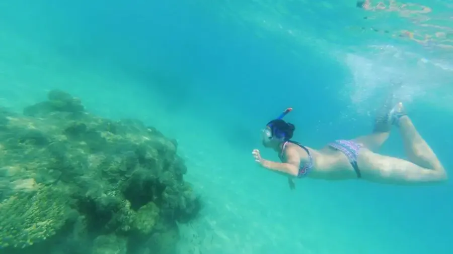 Mujer haciendo snorkel en aguas turquesas