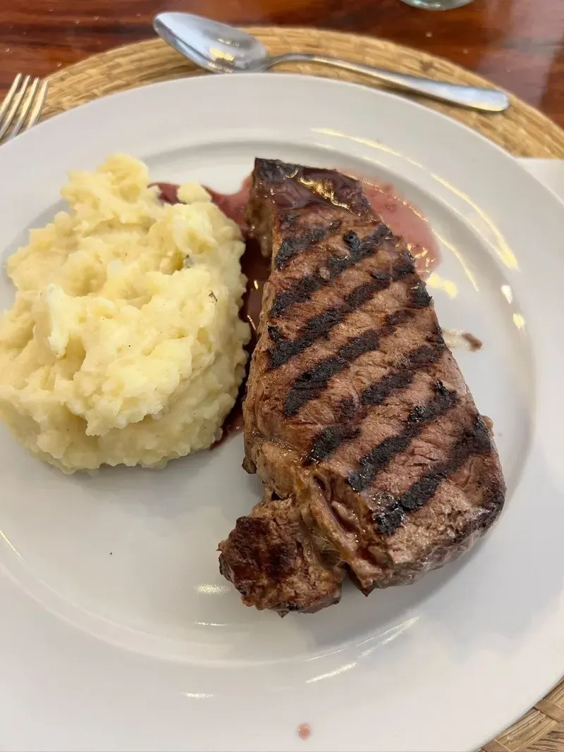 Bife a la parrilla con puré de patatas y salsa de vino tinto