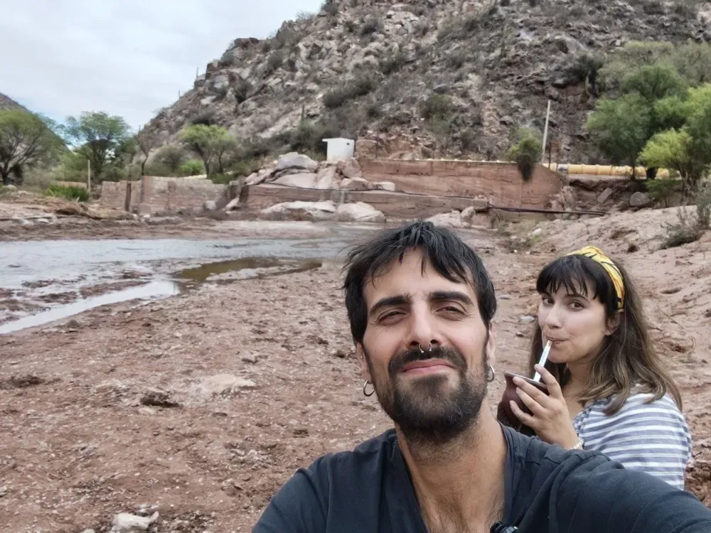 Sergi y Cris tomando mate junto al cauce del dique de Chañarmuyo