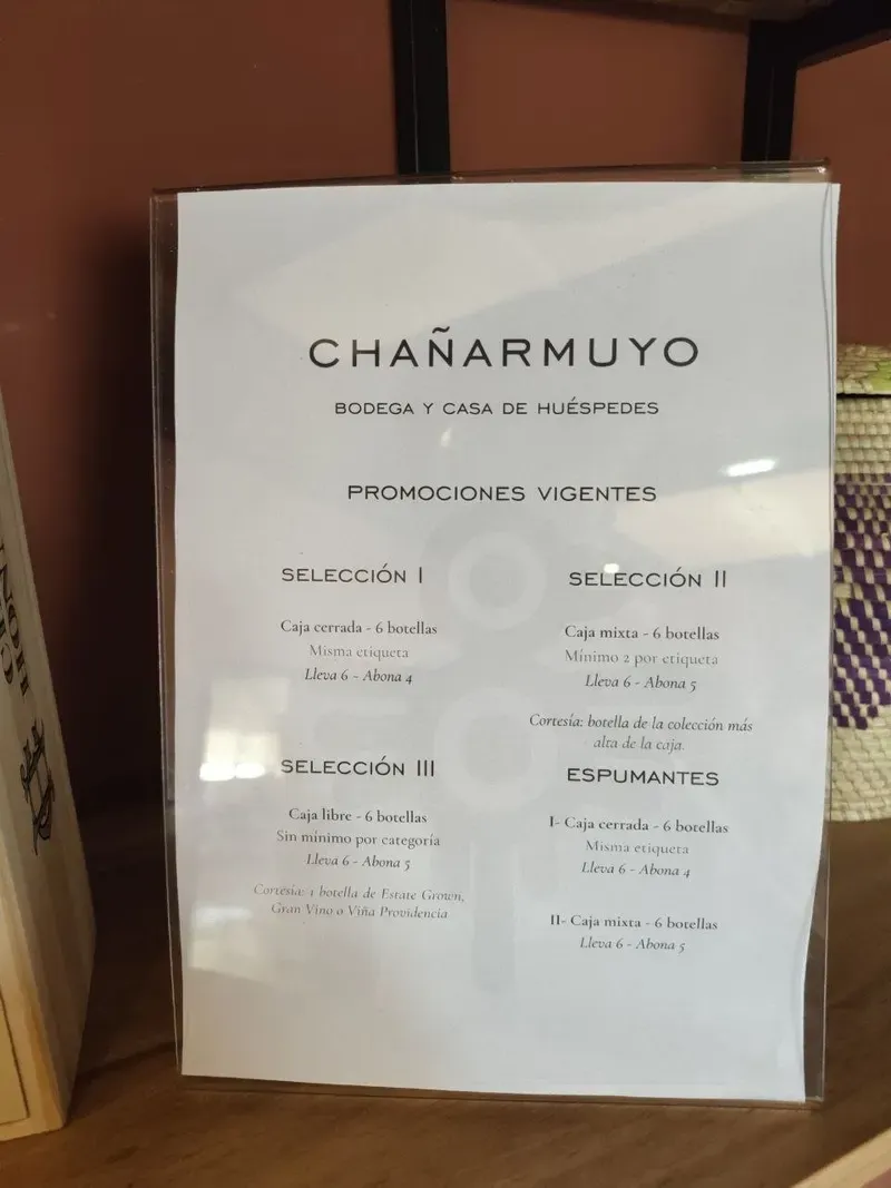 Cartel de promociones vigentes de la bodega Chañarmuyo con las ofertas por cajas de seis botellas