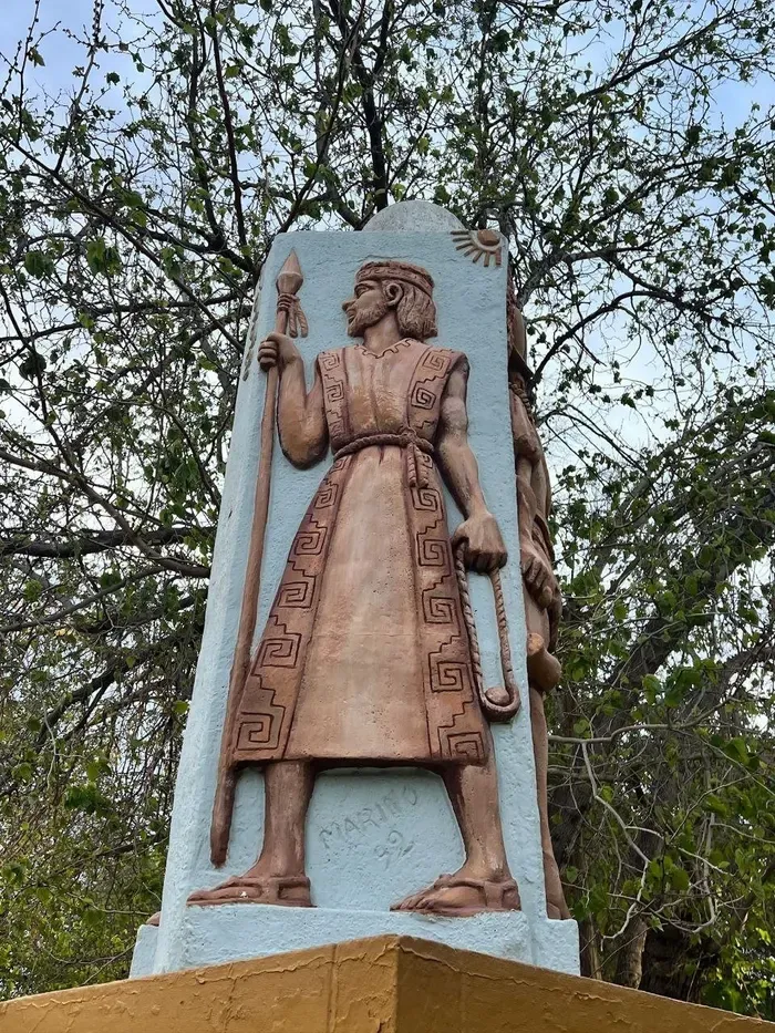 Relieve de un indígena con lanza y grecas en un monumento