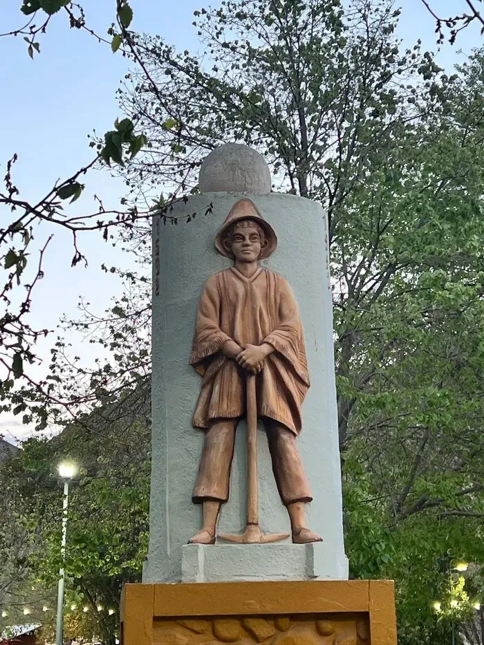 Relieve de un minero con poncho y pico en un monumento de Famatina