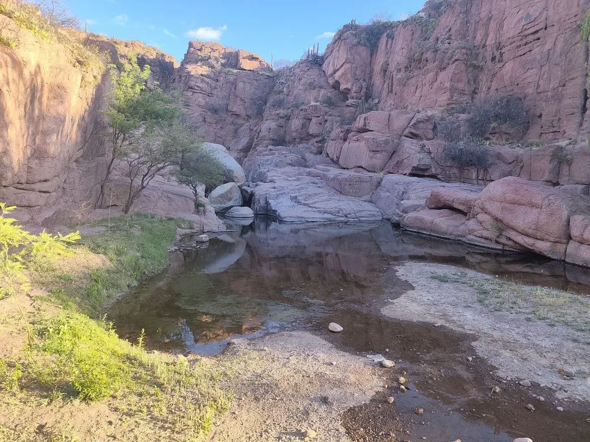 Agua y rocas rosadas en el fondo de la quebrada de Hualco