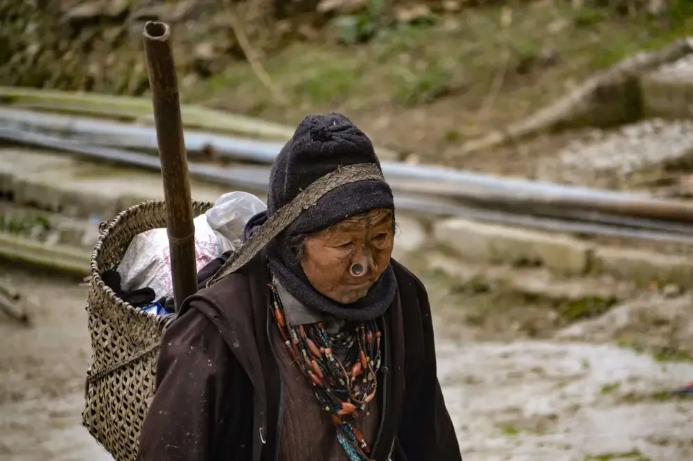 Mujer apatani anciana viniendo de trabajar