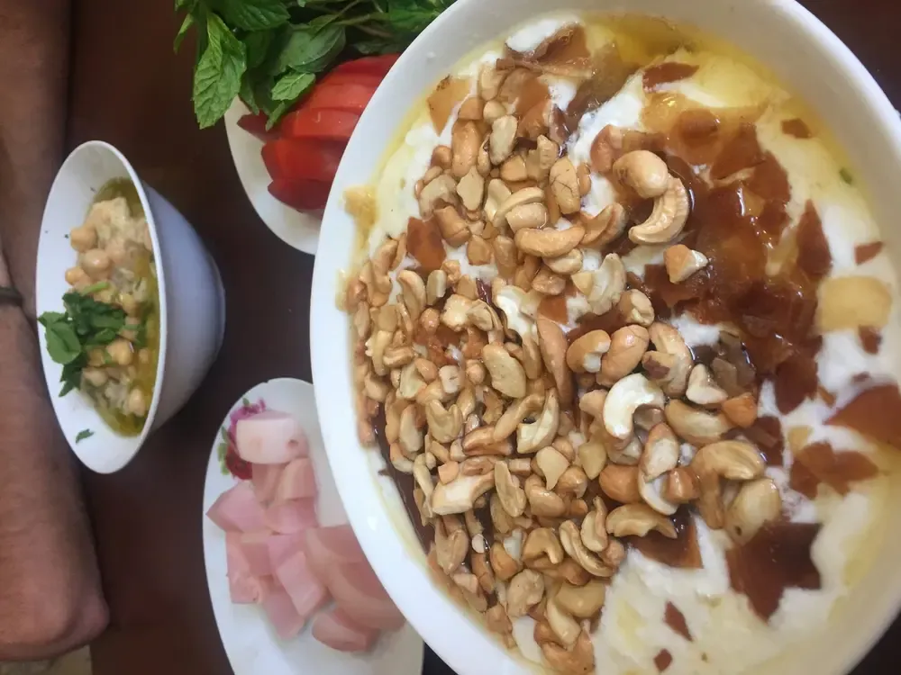 Plato de hummus acompañado de anacardos y pan de pita crujiente