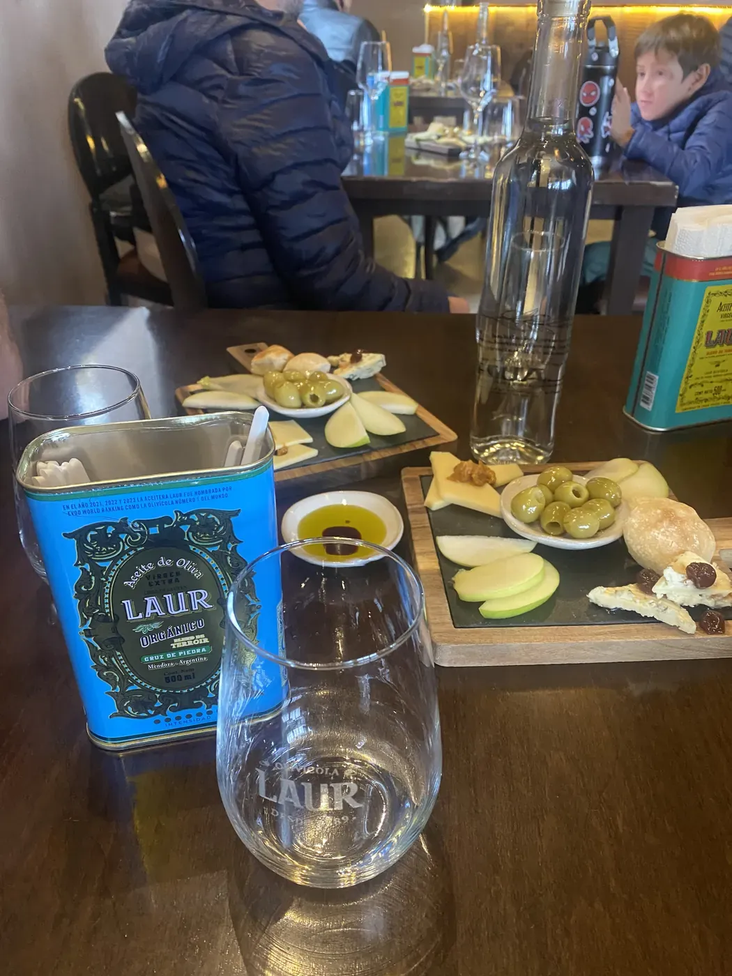Mesa con aceite de oliva Laur, aceitunas, queso y manzana mientras esperábamos el almuerzo