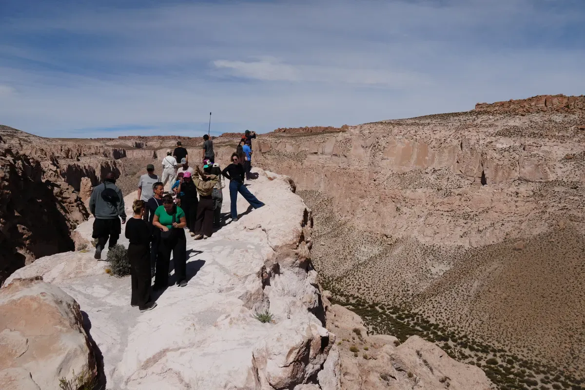 Grupo de viajeros en un mirador sobre un cañón del altiplano boliviano