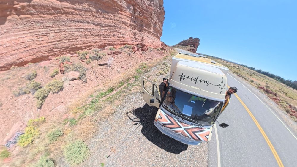 Cris y Sergi posando en camper con la formación rocosa en forma de Barco de fondo