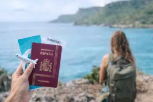 persona con pasaporte y avión preparando viaje frente al mar