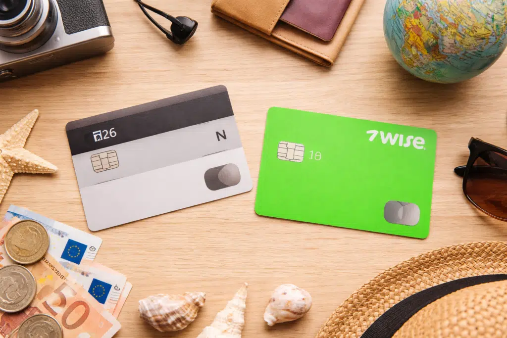 Tarjetas N26 y Wise sobre mesa de viaje con pasaporte, dinero y accesorios, comparativa para viajar sin comisiones